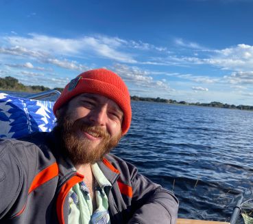 Daniel in front of a lake with the shore in the distance
