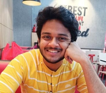 Sayanil sitting in a booth at a restaurant